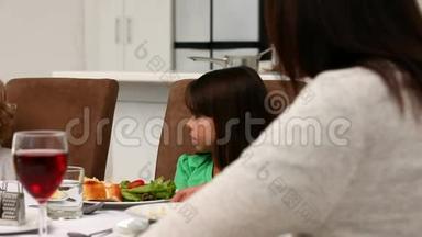 一个小男孩和她的母亲和妹妹一起同一桌